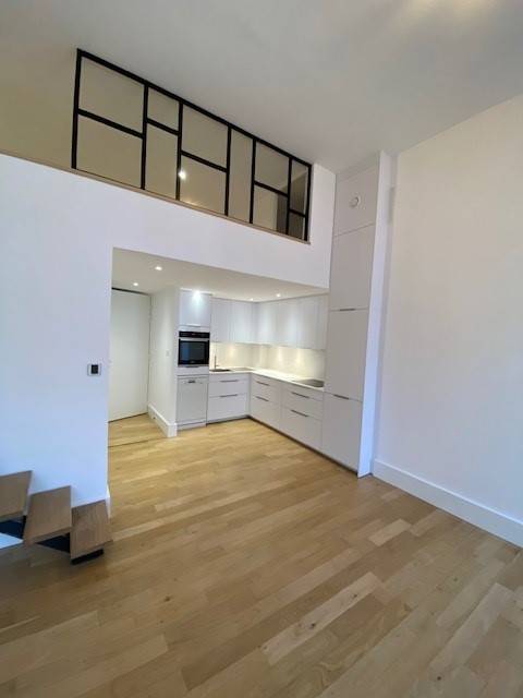 Pose d'une cuisine design blanche sous une mezzanine dans un appartement à Lyon 1